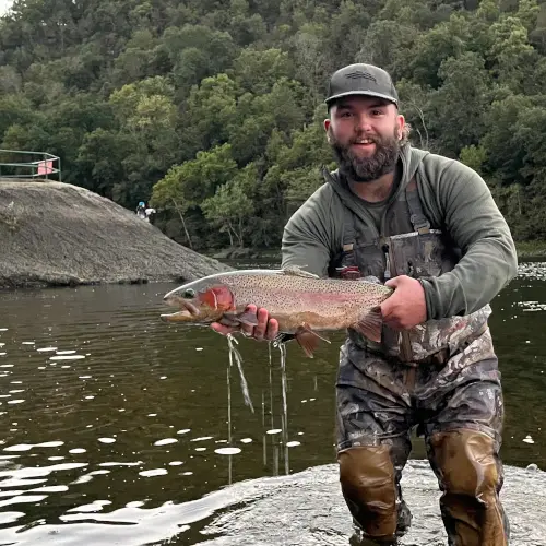 Fly fisherman showcasing a gorgeous, vibrant red, spawinng Rainbow Trout that was caught below Bull Shoals Dam on the White River.