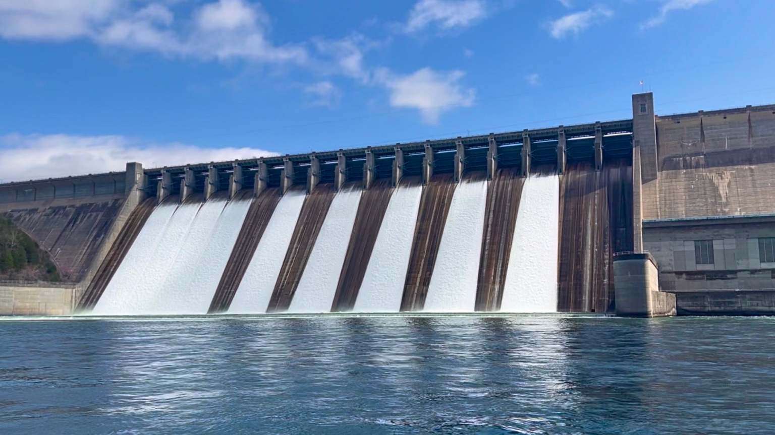 Picture of Bull Shoals Dam with the spillway gates open taken from the White River, Arkansas.